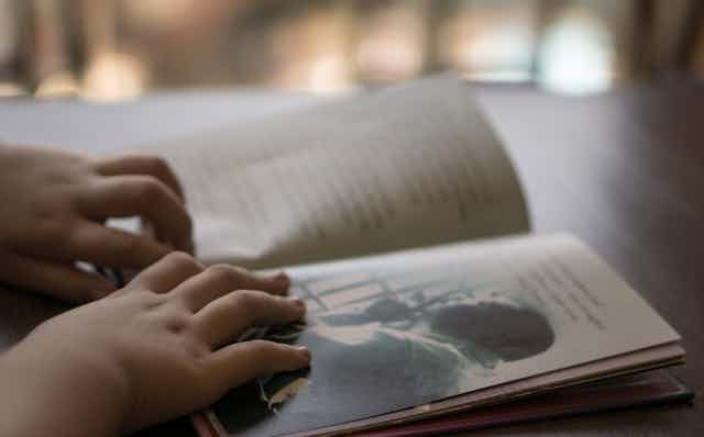 A child's hands on a book.
