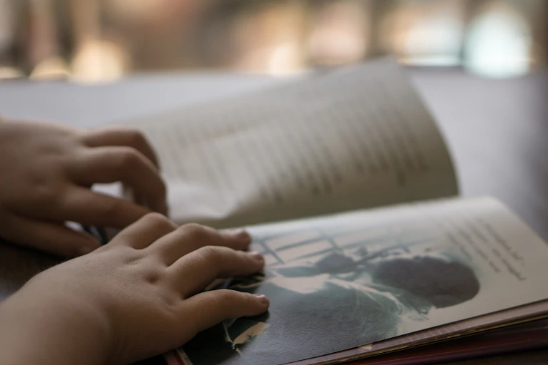 A child's hands on a book.