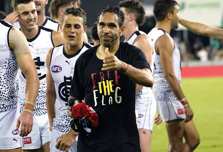 AFL player Eddie Betts wearing a t-shirt that says, 'free the flag'.