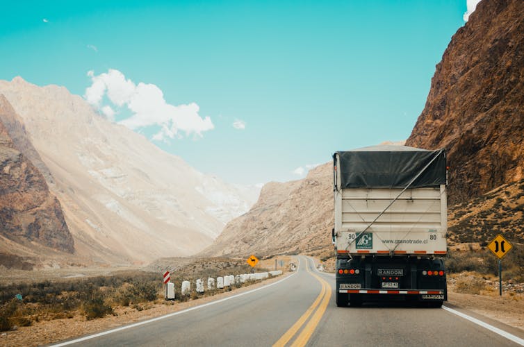 Truck driving along mountain road.