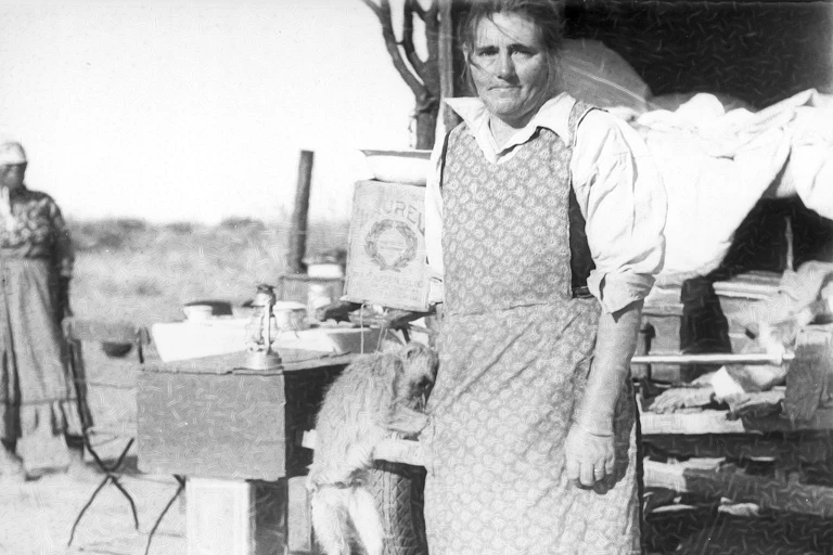 A white woman with a pet monkey and wearing a pinafore stands in front and behind her a black woman, her features indistinguishable.