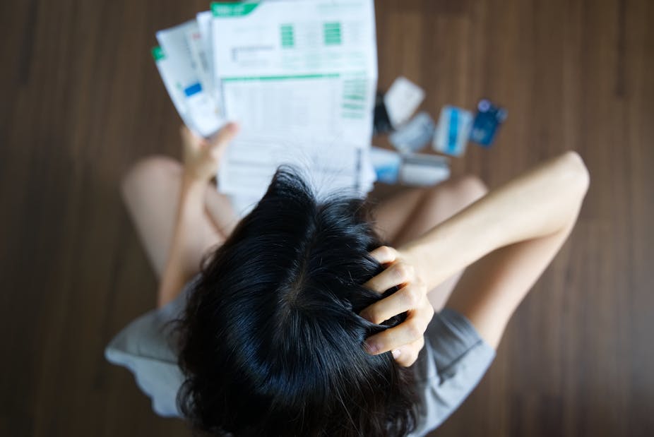 Woman worrying over a pile of bills