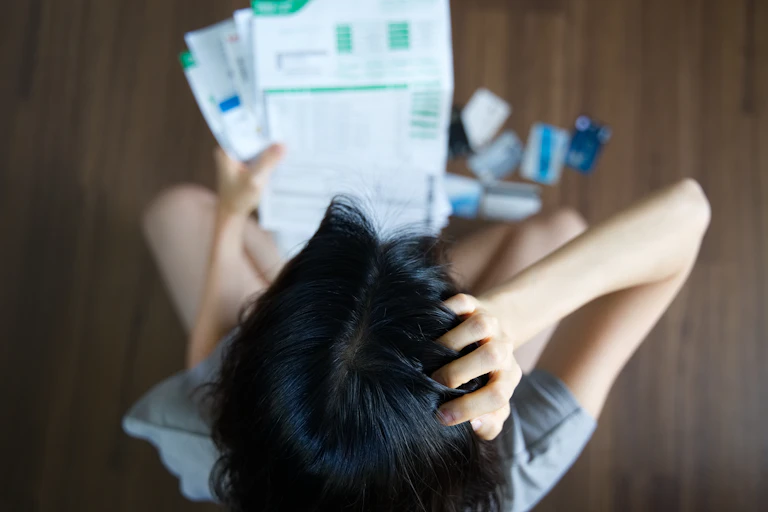 Woman worrying over a pile of bills