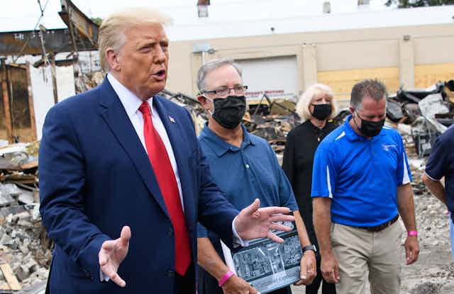 President Trump with business owners in rubble of store in Kenosha.