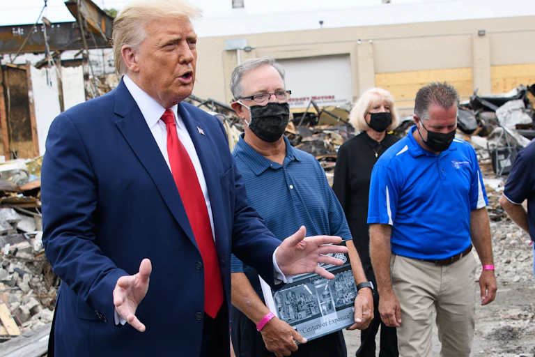 President Trump with business owners in rubble of store in Kenosha.