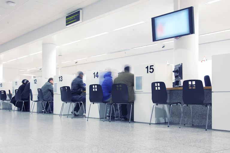Fila de puestos de atención a la ciudadanía en oficina de administración pública.