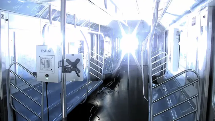 ultraviolet light filling the interior of an empty New York City subway car
