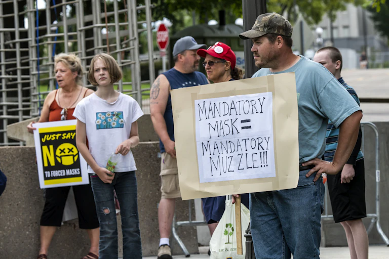 Protestors with anti-mask signs