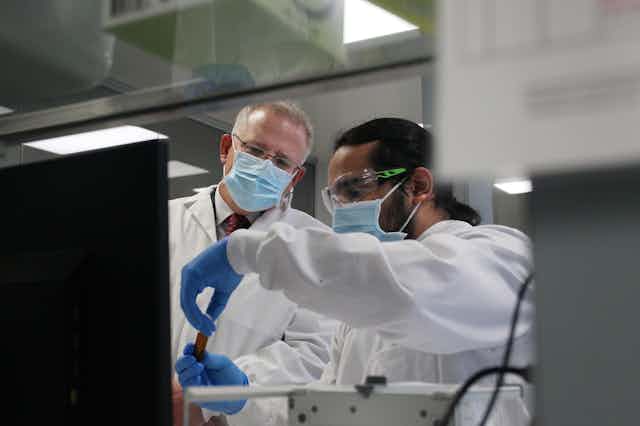 Scott morrison and a AstraZeneca employee examining a lab