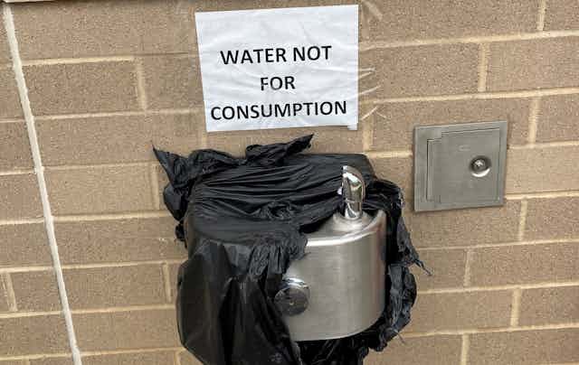 A water found wrapped in plastic with a sign reading "water not for consumption."