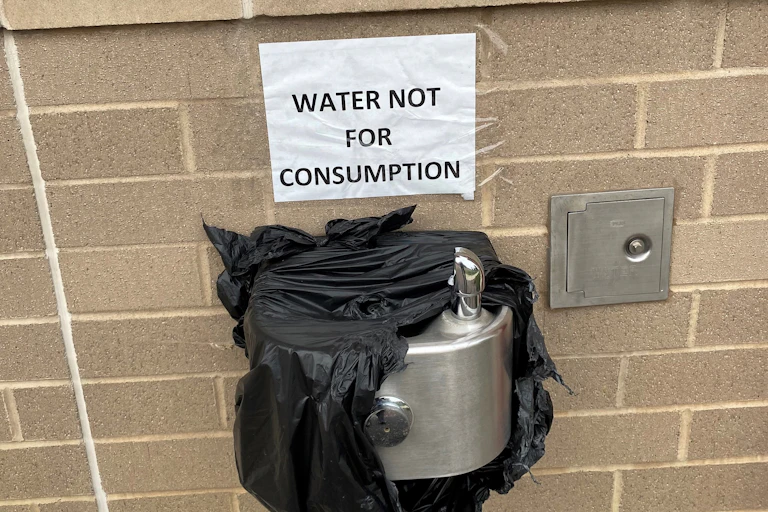 A water found wrapped in plastic with a sign reading "water not for consumption."
