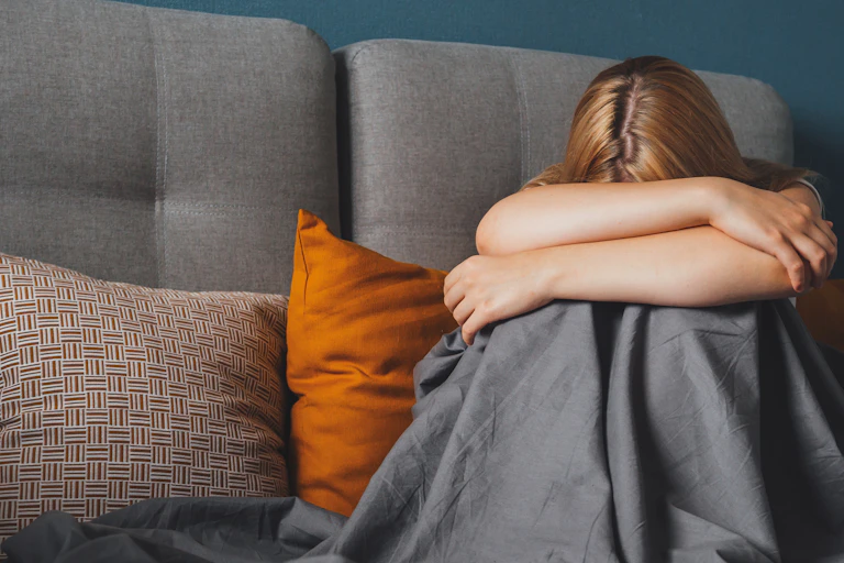 Girl cradling head in bed