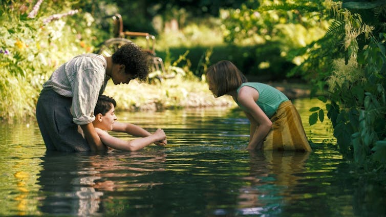 Dickon and Mary bathe Colin in a stream.