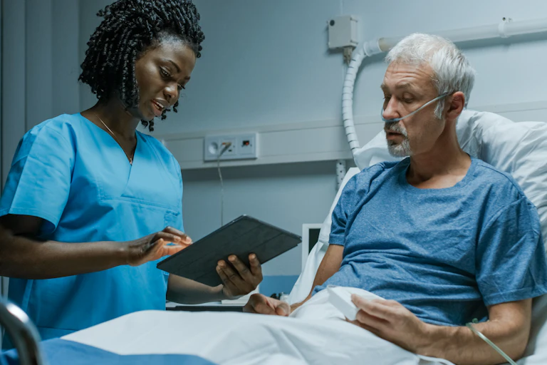 A nurse speaking to a patient in hospital.