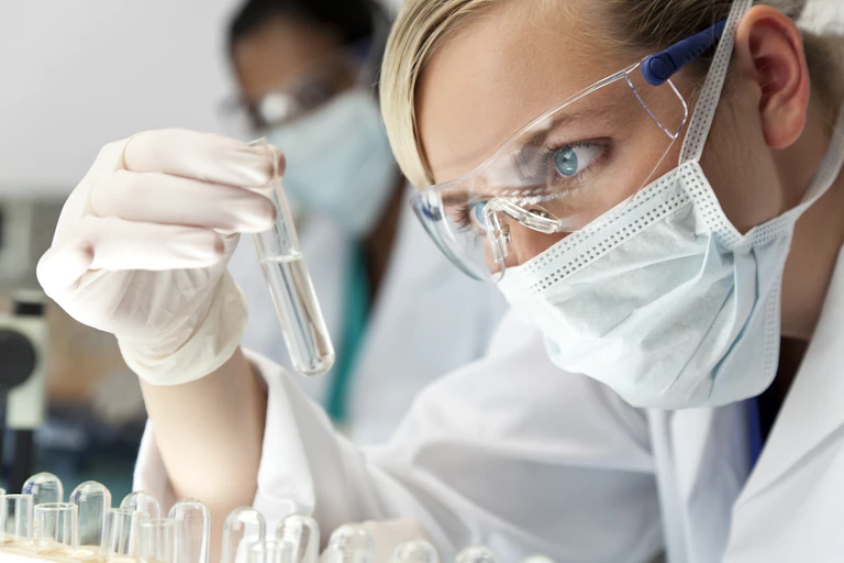 Scientists looking at liquid in a test tube