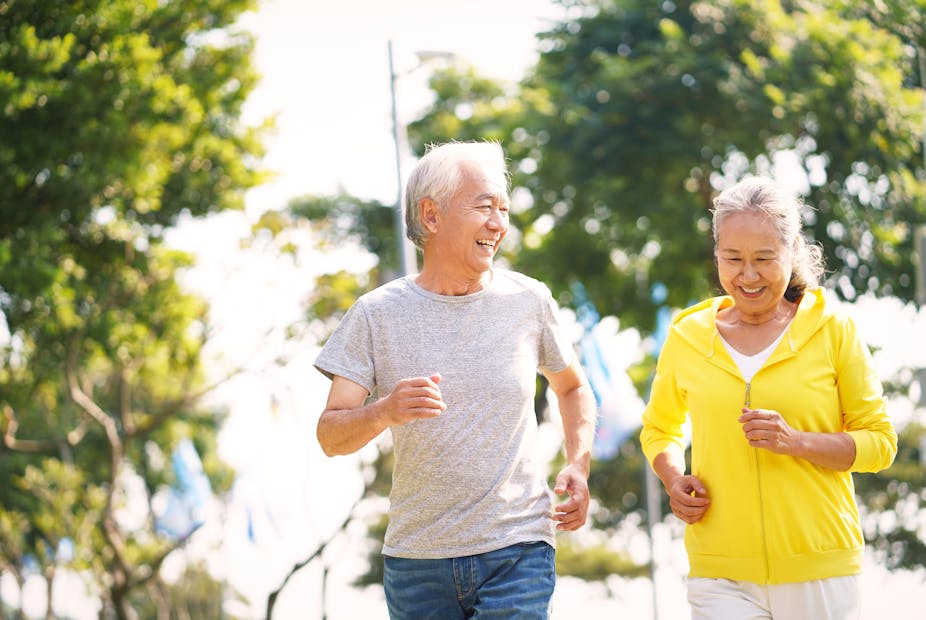 Elderly man and woman jog together.
