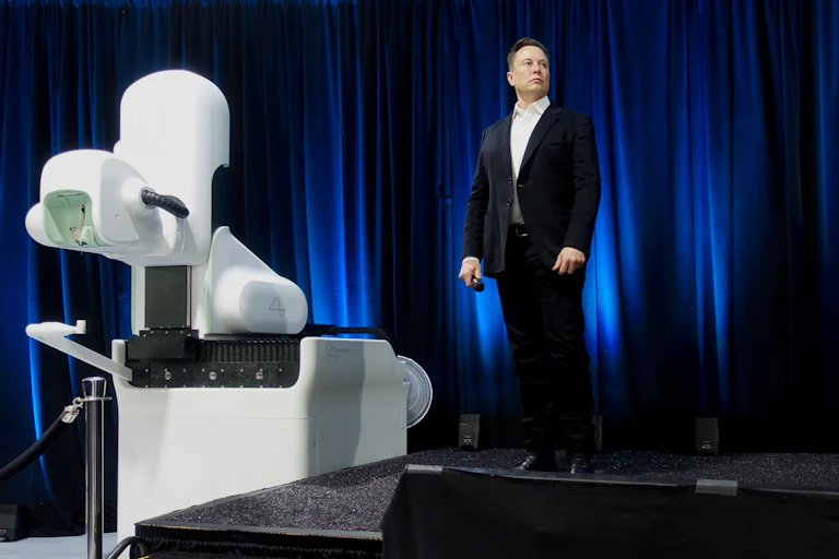 Picture of Elon Musk at Neuralink presentation with robot.
