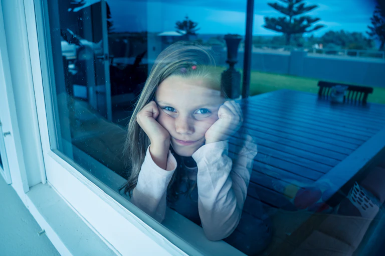 Bored girl during lockdown, staring out the window