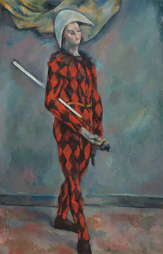 Harlequin in a red and black diamond pattern jumpsuit holding a sword.