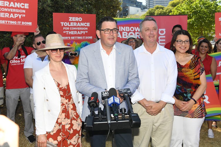 Daniel Andrews at press conference with 'zero tolerance for conversion therapy' signs