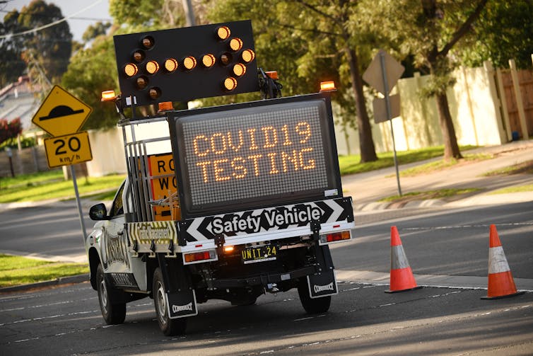 Ute with sign pointing towards COVID testing facility