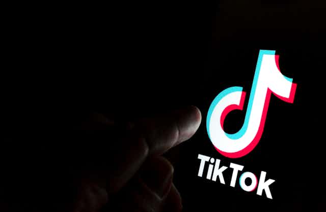 The TikTok symbol is displayed on a phone screen.