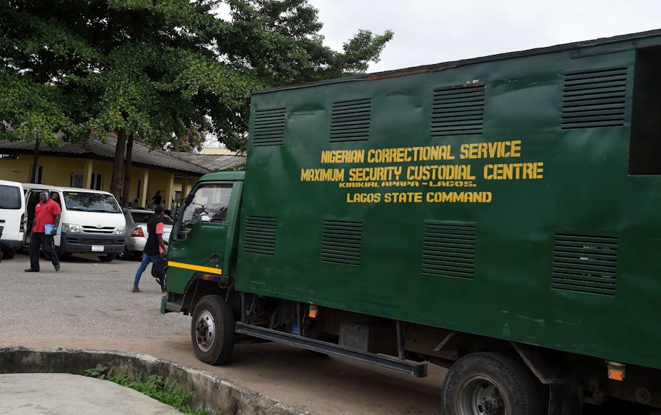 People walk past truck used fro conveying inmates to the prison in Lagos State High Court, Ikeja, Lagos, Nigeria 