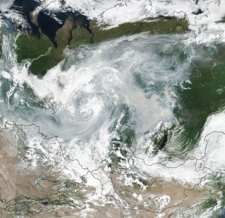 A satellite image shows smoke and clouds swirling over Russia.