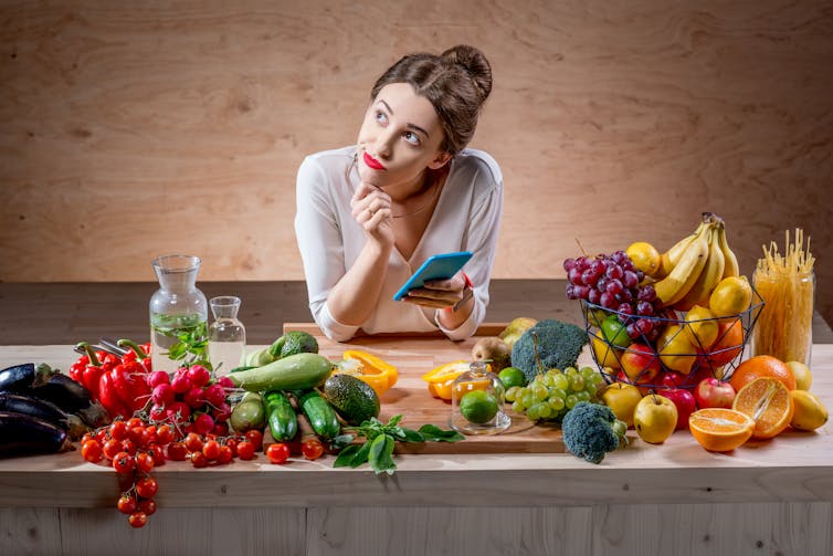 Young woman uses smartphone to track food calories.