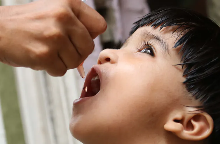 A boy in Pakistan being given an oral polio vaccine.