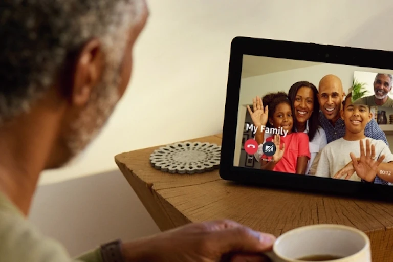 Man watching Amazon Echo Show drinking coffee
