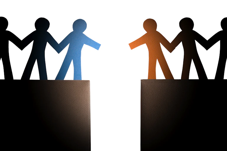 Two groups of people attempting to reach each other across a large gap.
