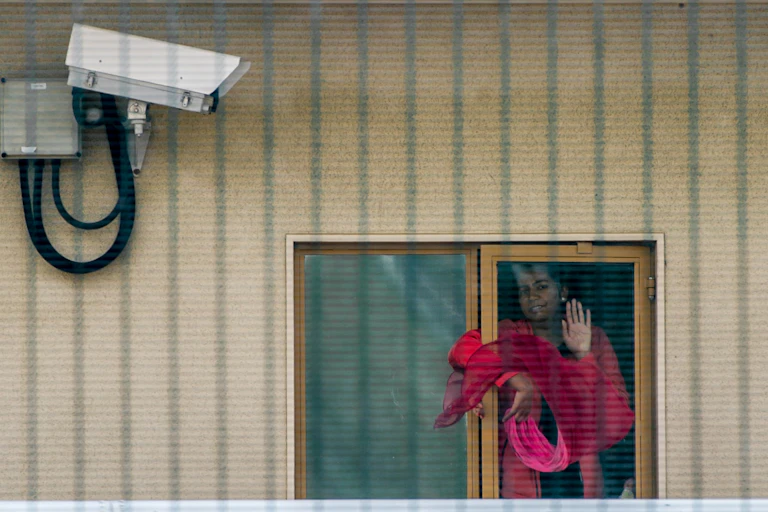 Woman at window of detention centre.