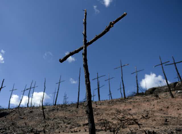 burned stick crosses on a bare hillside