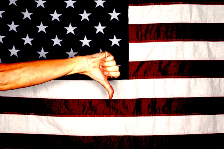 American flag with hand making a thumbs down