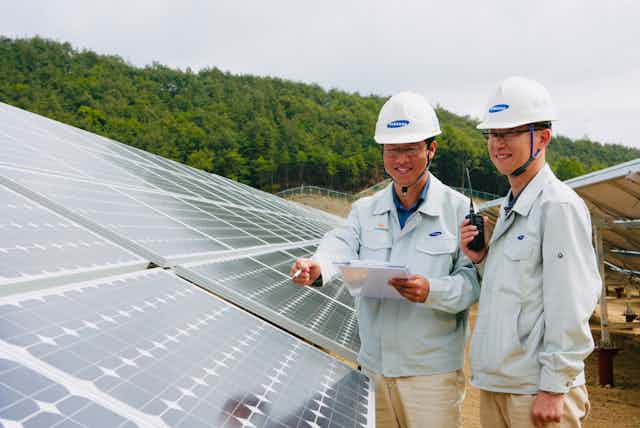 Two men inspect a sollar array