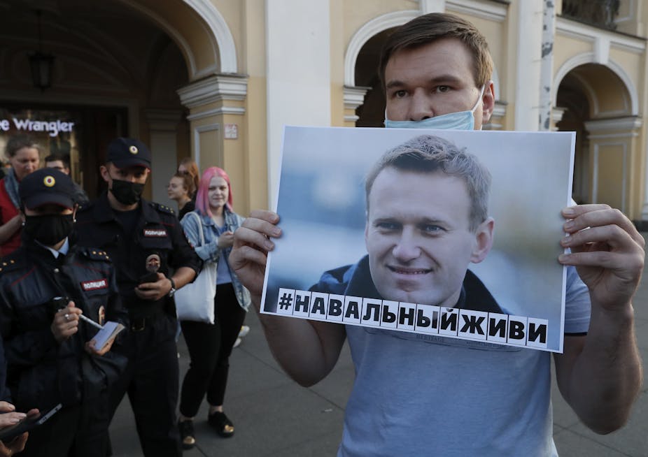 Man holding poster of Alexei Navalny.