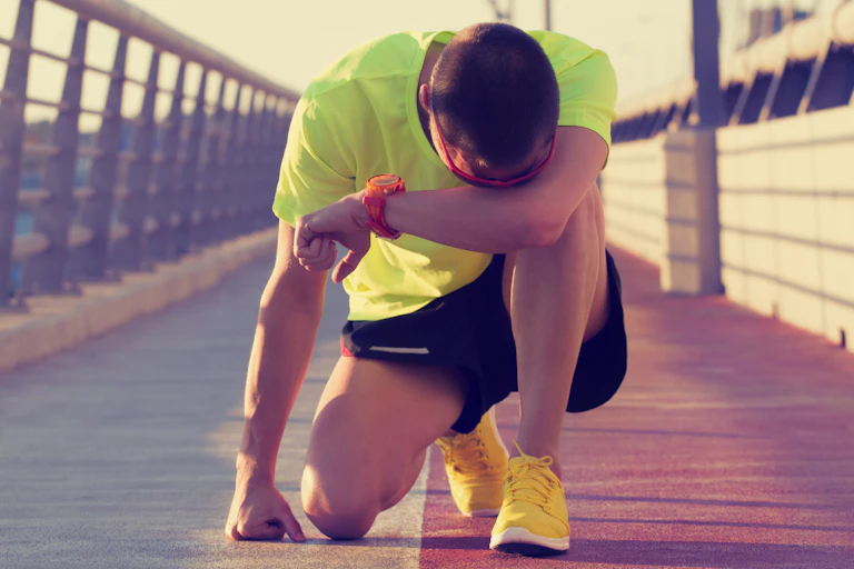 Exhausted runner kneeling on the ground.