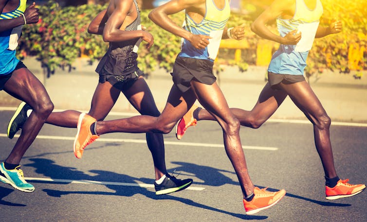 Four long-distance runners running.