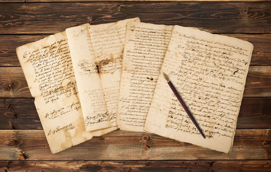 Old letters fanned out with a ink nib pen on top.