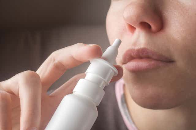 Una mujer se acerca a la nariz un aplicador nasal.