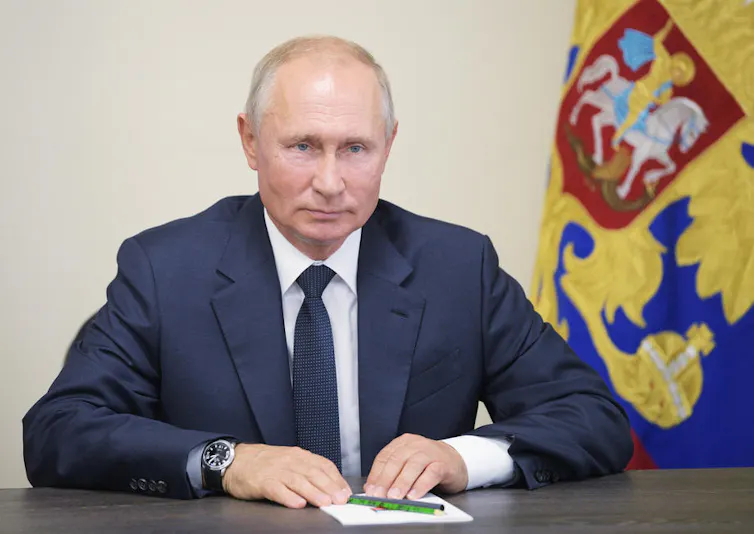 Vladimir Putin net to a flag.