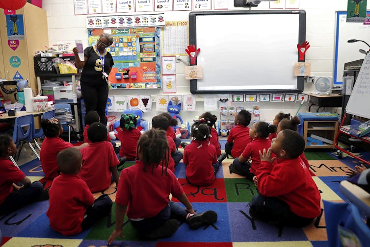 A teacher leads a pre-kindergarten class.