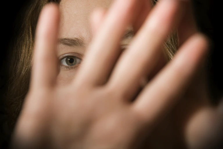 A woman using her hand to say "Stay away!"