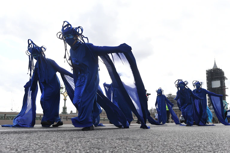 Protesters in blue dresses march down Westminster Bridge in London, UK.