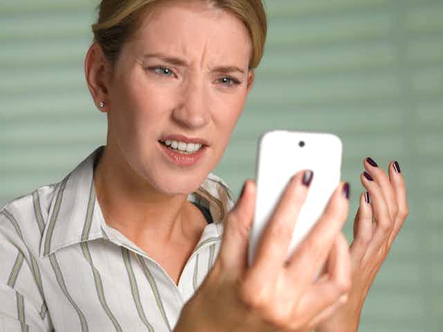 Annoyed woman looking at a smartphone