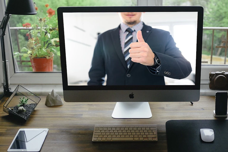 A man gives a thumb's up on a computer screen.
