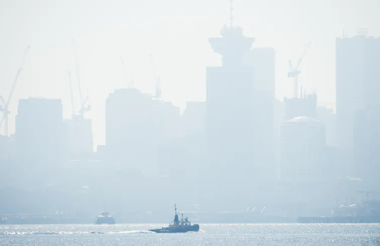 Smoky skyline with boat in the foreground.