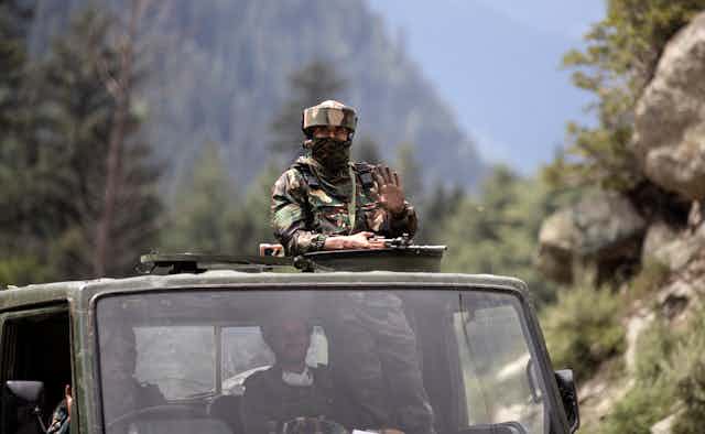 Indian soldier on top of truck with gun in Kashmir