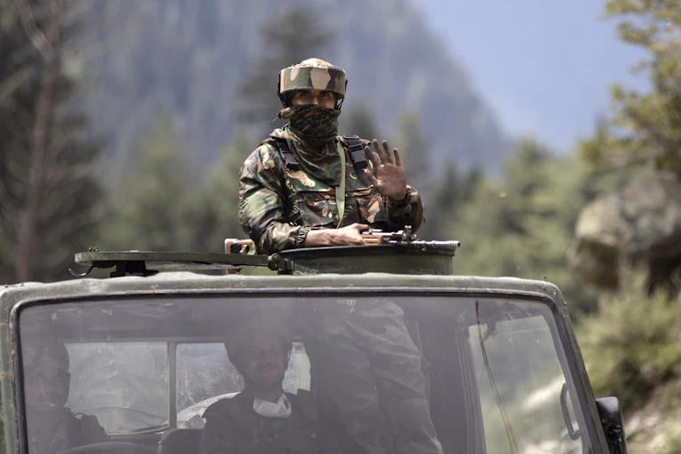 Indian soldier on top of truck with gun in Kashmir